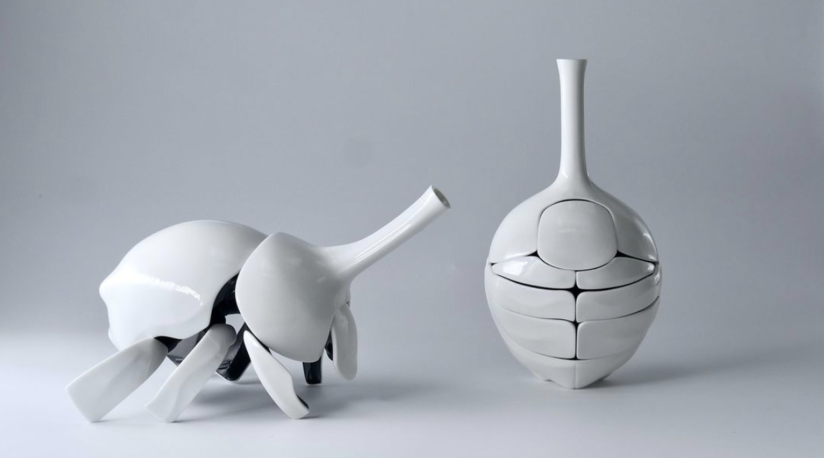 a white ceramic beetle folds into a flower vase